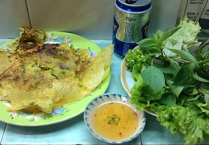 Bánh xèo vàng giòn ăn kèm rau sống và nước chấm