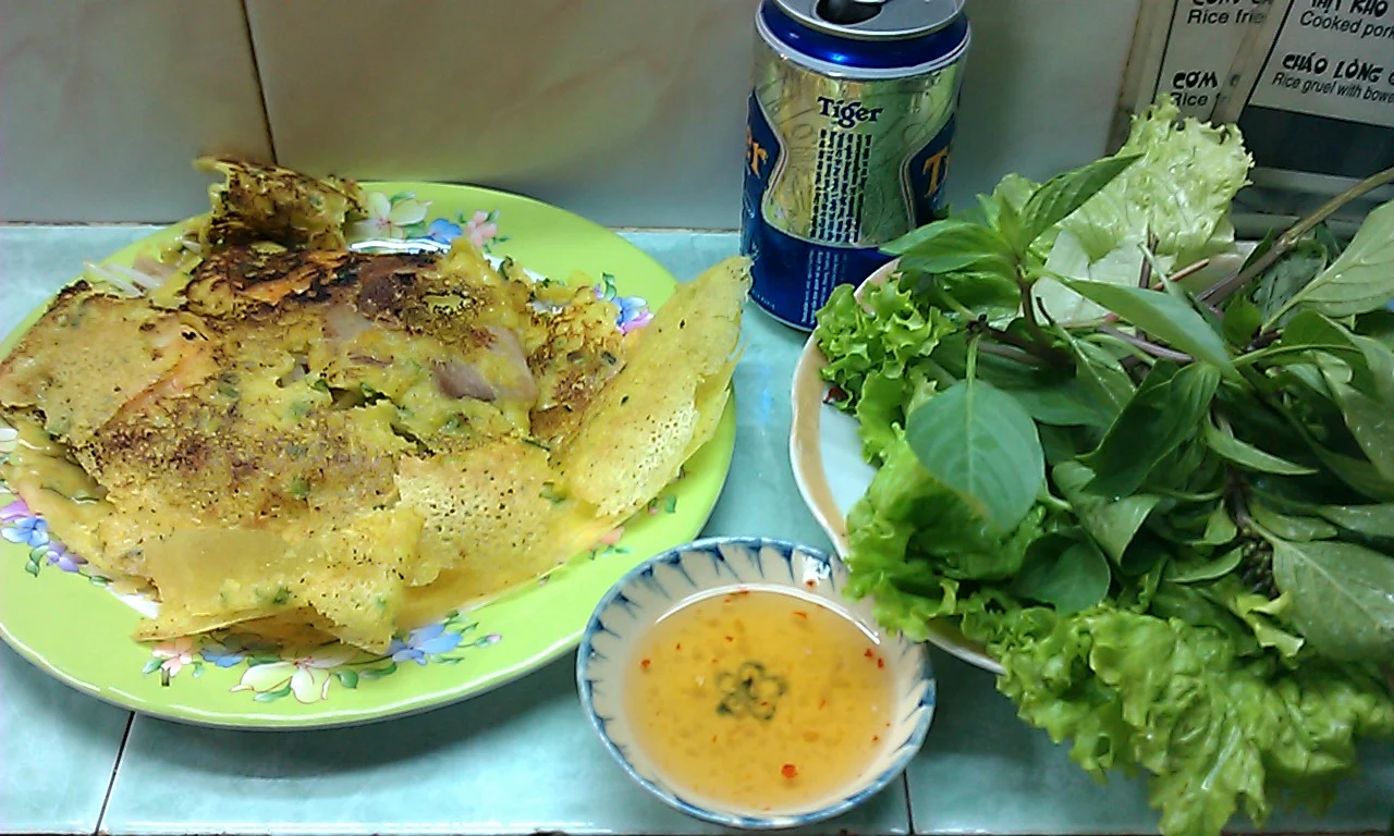 Bánh xèo vàng giòn ăn kèm rau sống và nước chấm